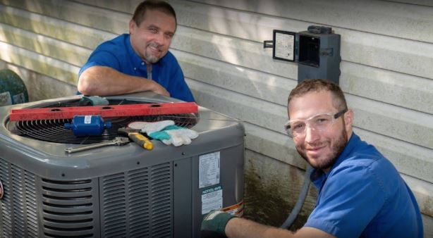 RS Andrews AC maintenance techs at Chesapeake, VA, home tuning up the air conditioning system in the backyard.