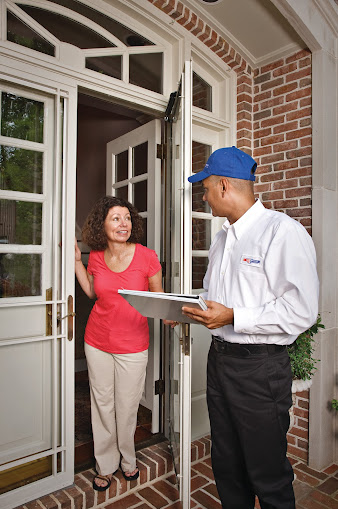 An HVAC technician meets a homeowner at the door